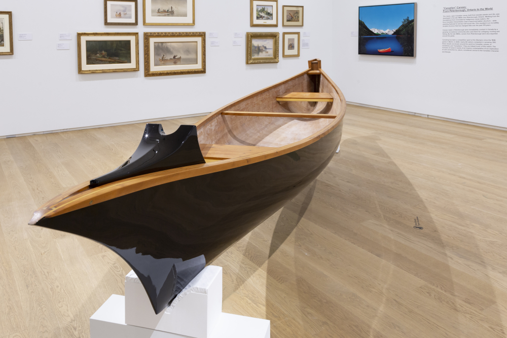 a handmade canoe in the midddle of a museum gallery
