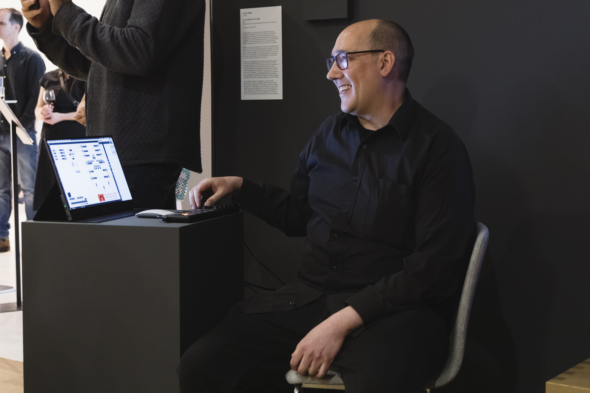 Artist Darren Miller sits in front of a computer