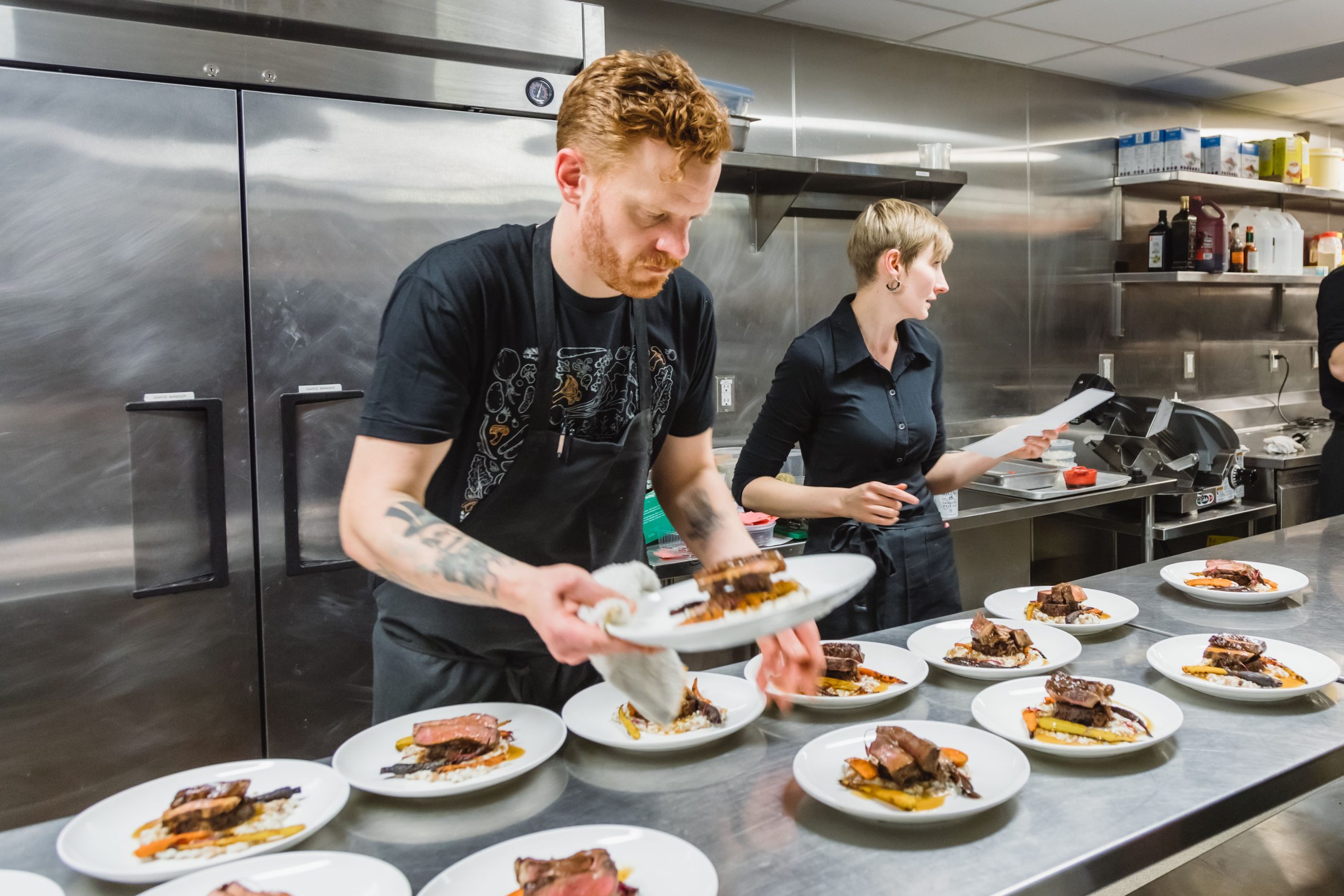 Hearth co-owners Thayne Robstad and Beth Rogers prepare a number of dishes in a kitchen.