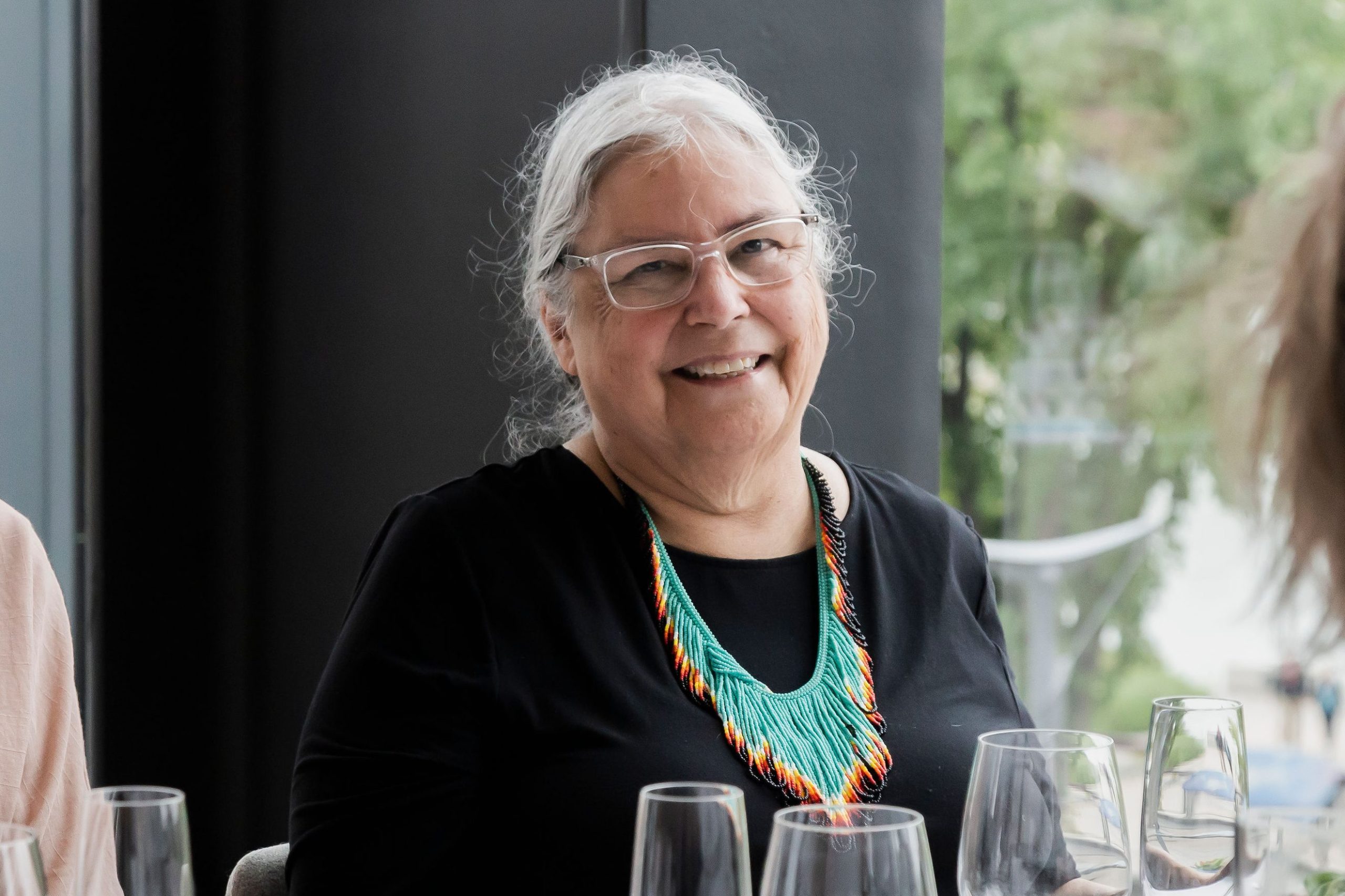 Ruth Cuthand smiles at the camera at a Remai Modern dinner event.