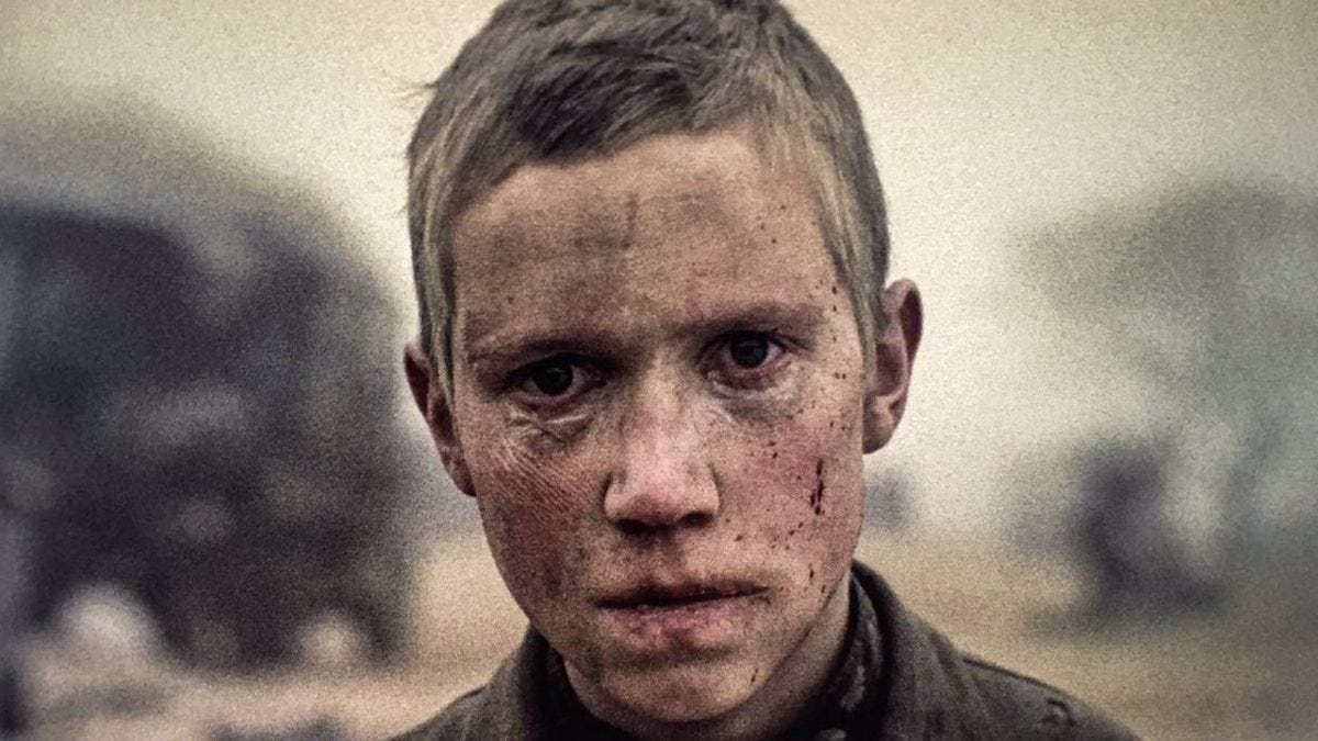 This image features a close-up of a young boy's face, with a somber and haunted expression.