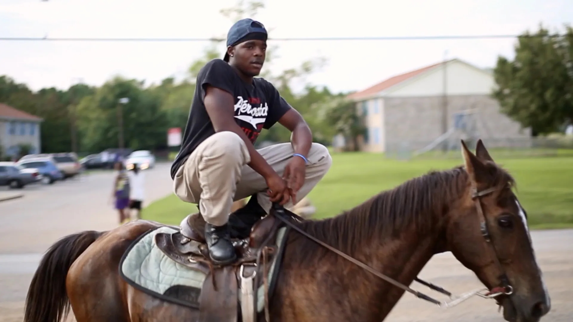 A man sits on a horse, embodying the spirit of adventure and companionship. Houses and streets make up the backdrop.