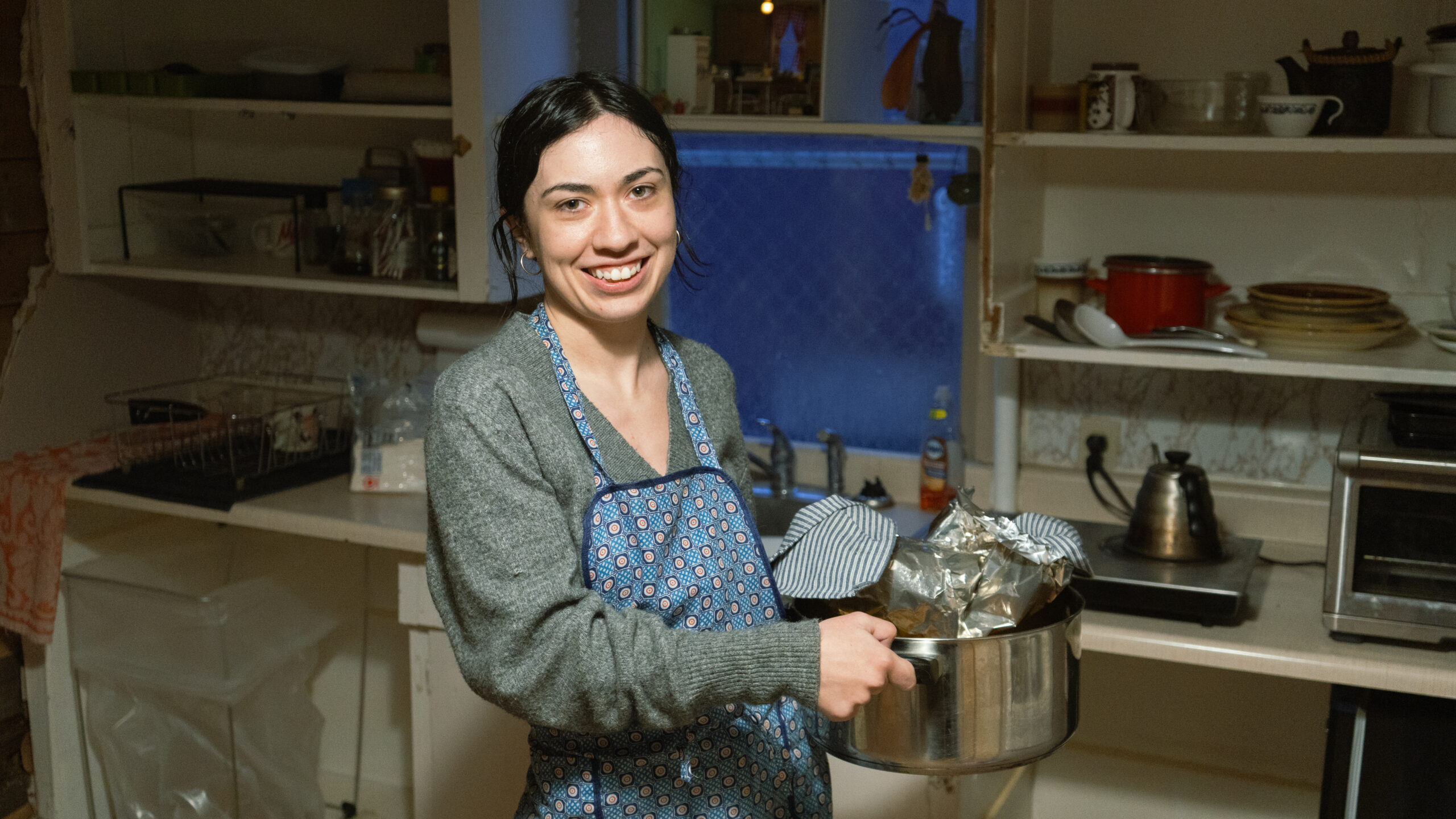 A portrait of artist Gabby Da Silva holding a steel pot