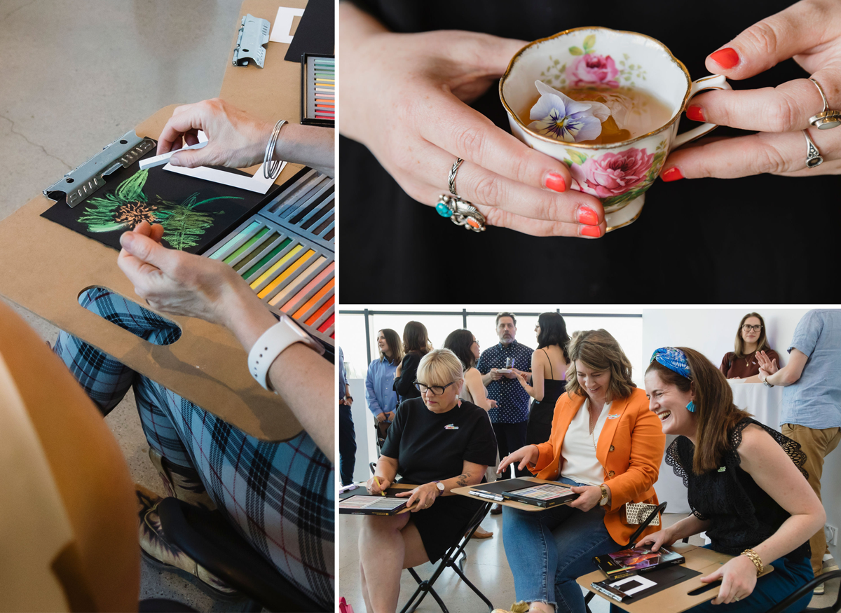 Three adults sit in folding chairs at a museum event, smiling and laughing while holding art-making boards and materials. Other attendees stand and talk in the background, creating a lively, social atmosphere.